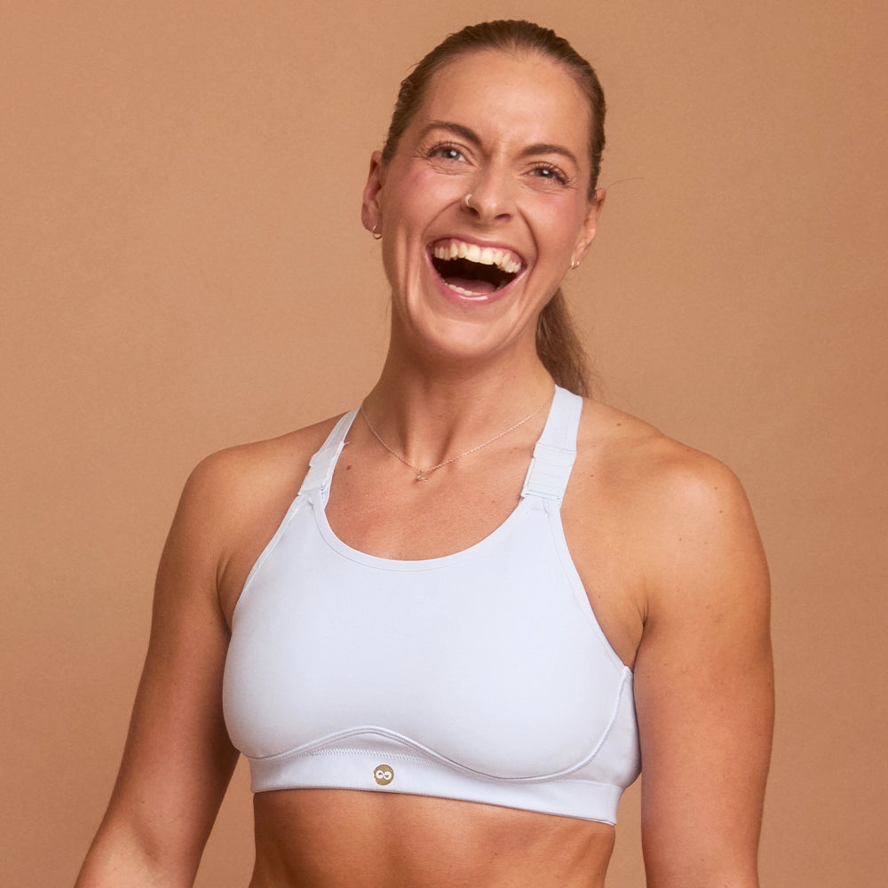 Laughing woman in light blue adjustable sports bra designed for high support
