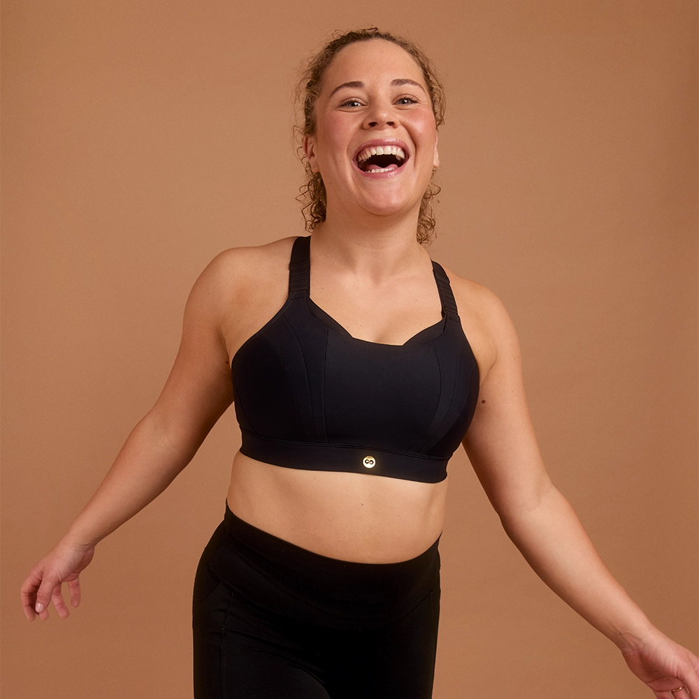 Laughing woman in black high impact sports bra