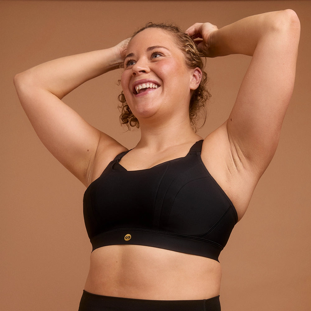 Smiling woman in black high support sports bra