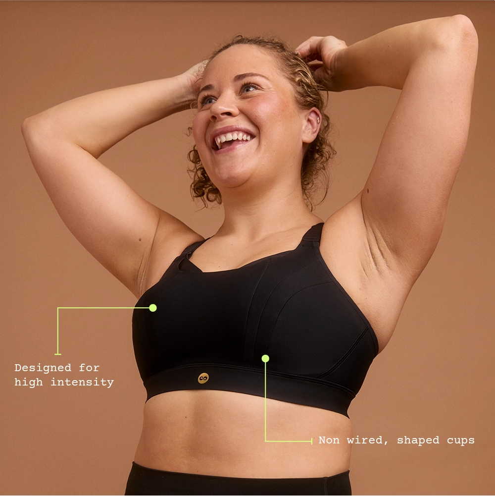 Smiling woman in black high support sports bra