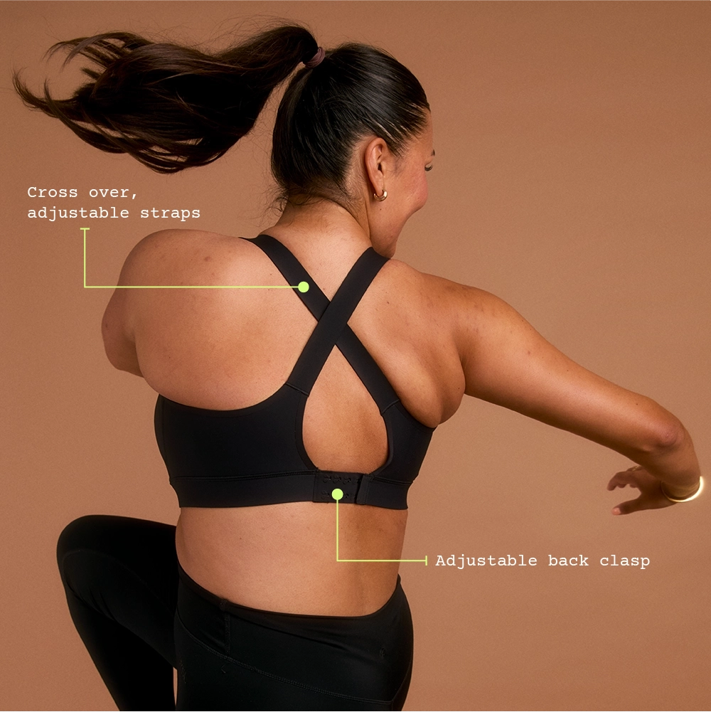 Woman in black cross-back sports bra lifting knee in active pose