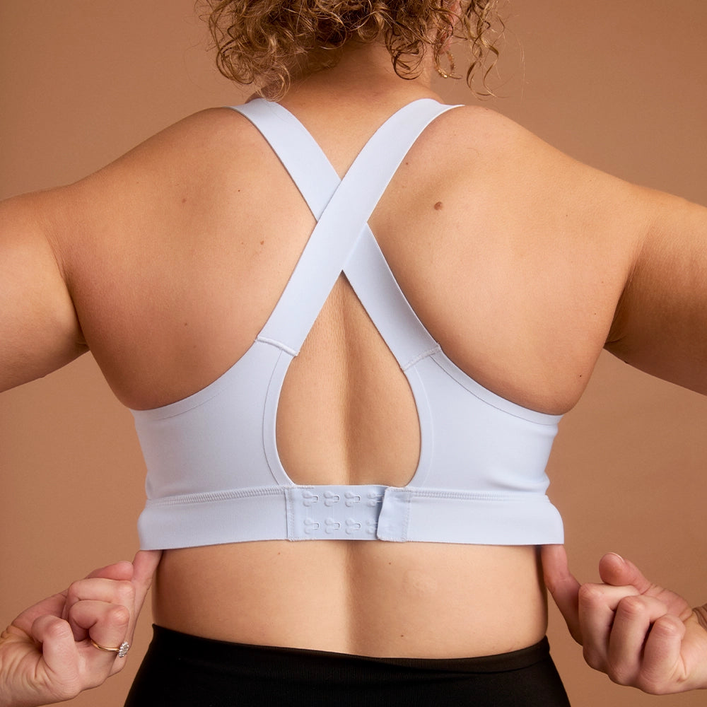 Back view of woman in light blue cross-back high impact sports bra