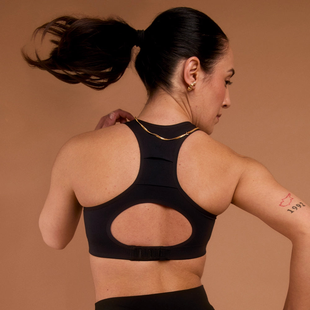 Woman in black high-impact racerback sports bra, showing back support