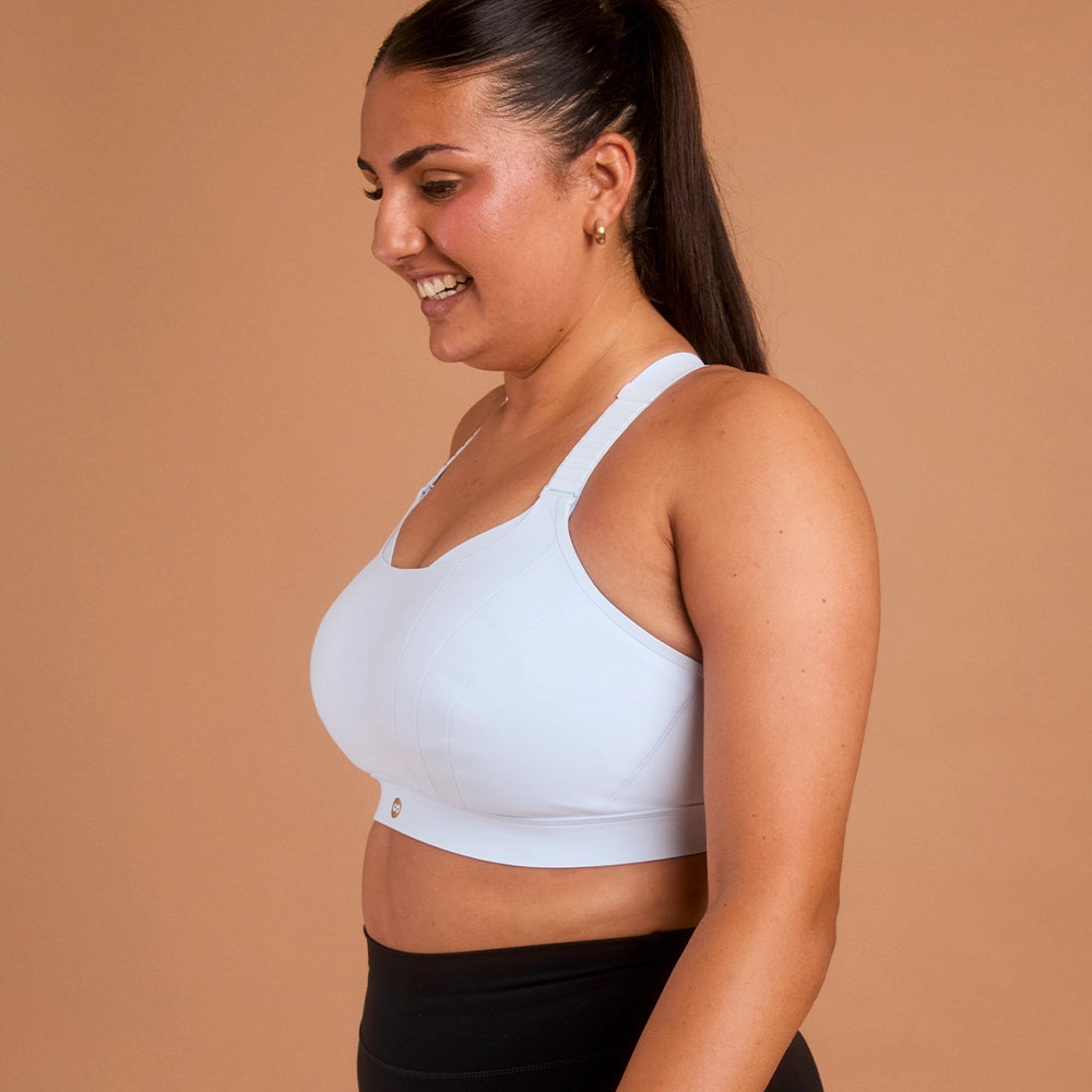 Side view of woman in light blue supportive high impact sports bra