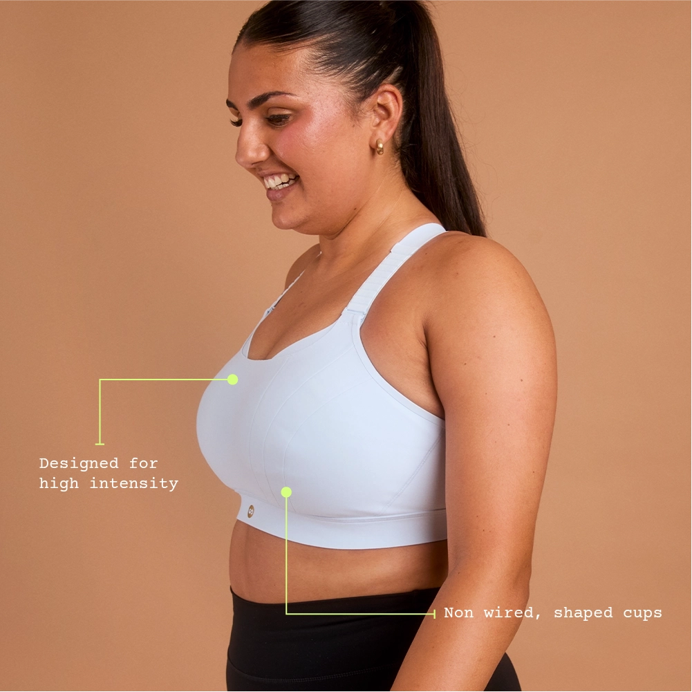 Side view of woman in light blue supportive high impact sports bra