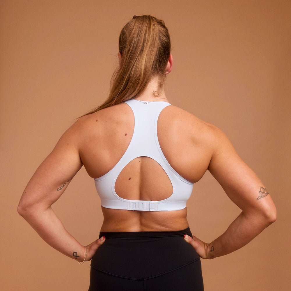 Back view of woman in light blue racerback sports bra with clasp closure