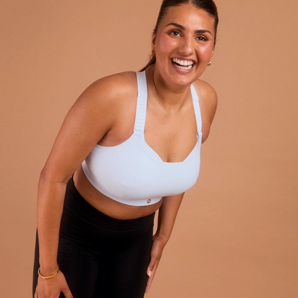 Laughing woman in light blue adjustable sports bra for big bust support