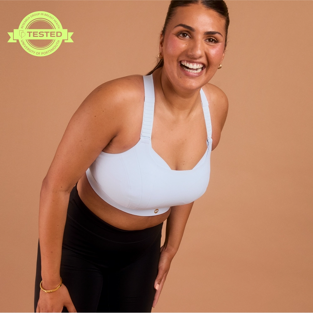 Laughing woman in light blue adjustable sports bra for big bust support
