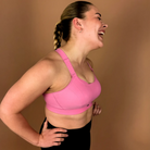Side view of pink Gravity high impact sports bra with adjustable straps, supportive fit, hands on hips pose.