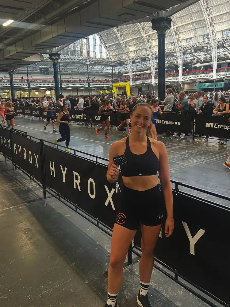 Athlete Leah Salvage in black sports bra smiling after Hyrox competition.