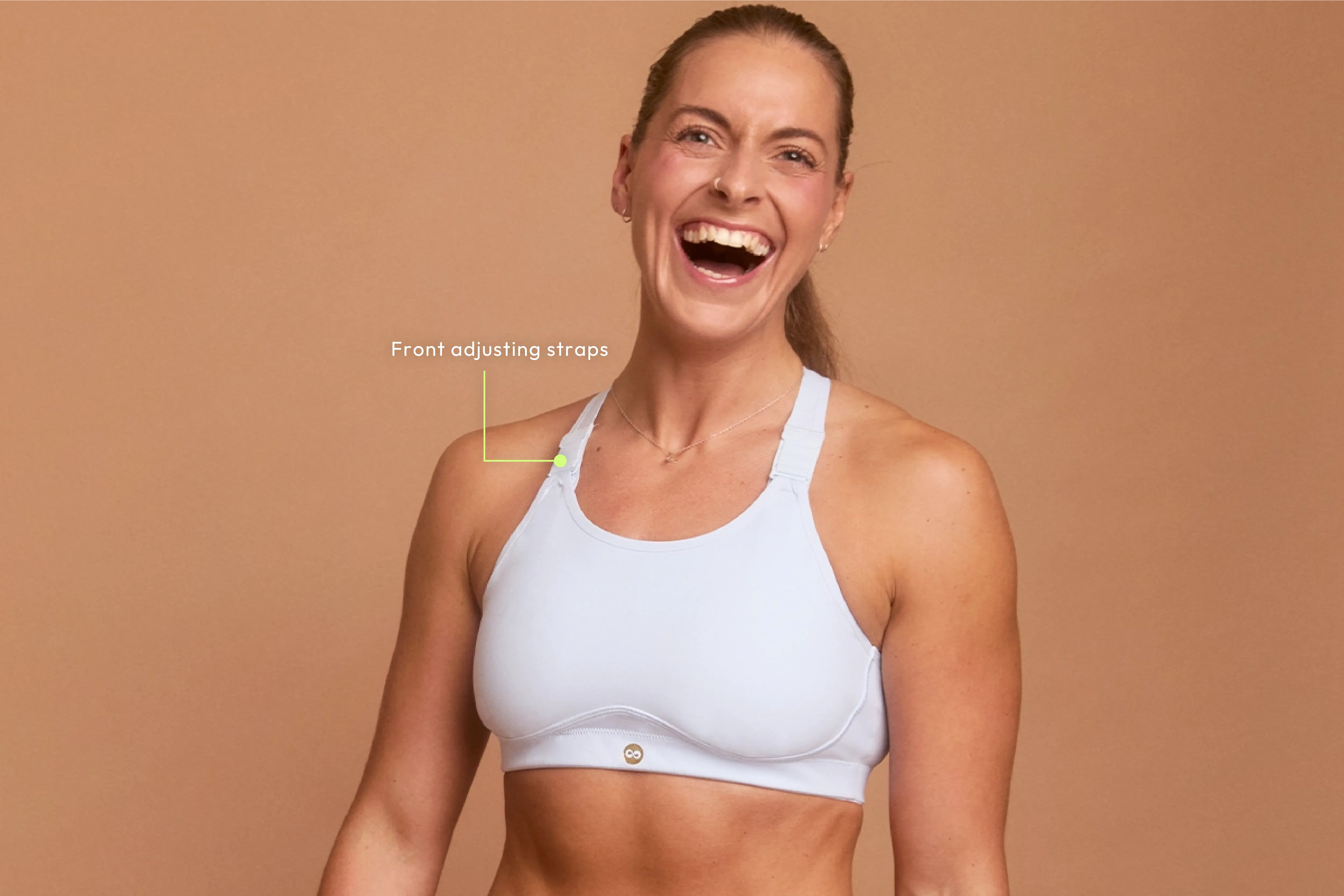 Woman smiling in blue sports bra with front-adjusting straps for custom fit.