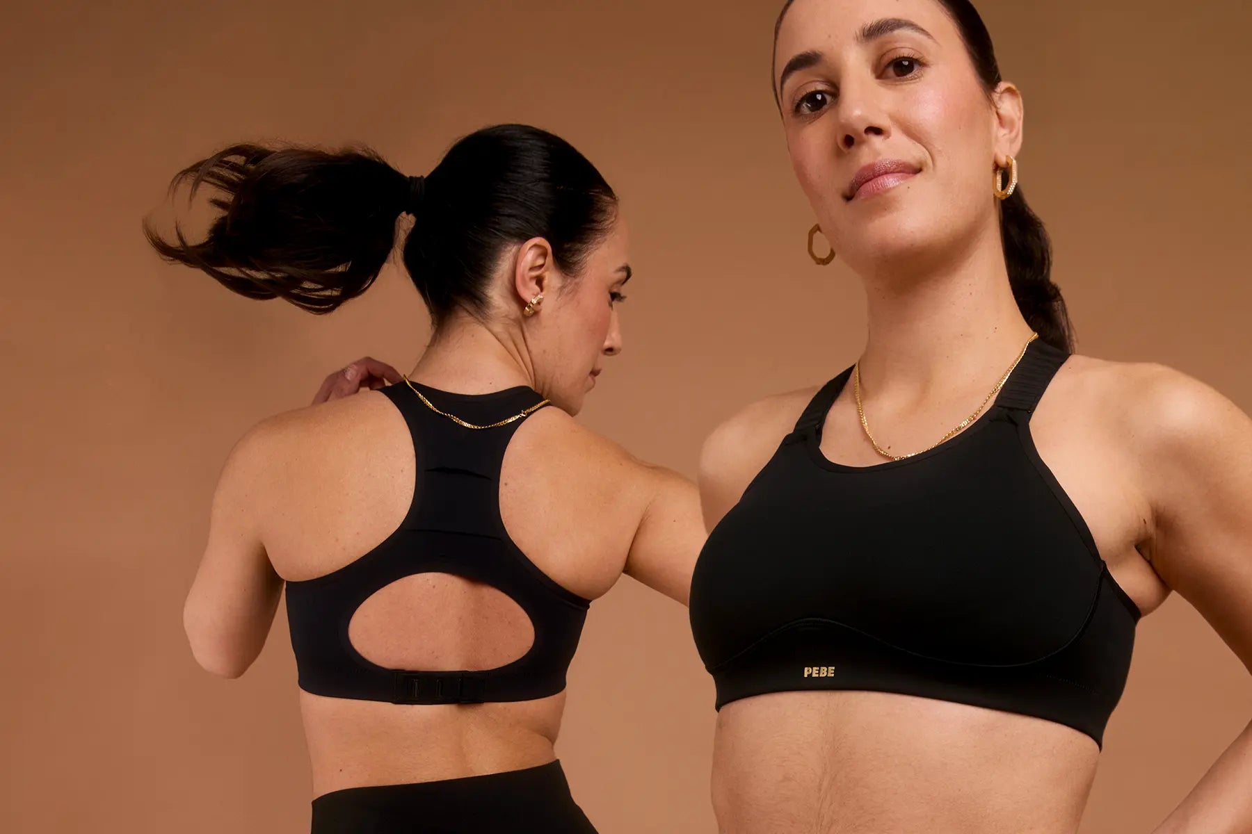 Woman wearing black sports bra shown from front and back with racerback and gold PEBE logo.