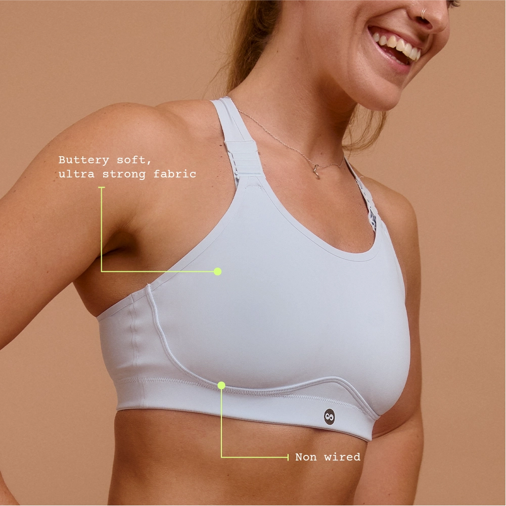 Smiling woman in light blue sports bra for high-impact hyrox training