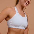 Smiling woman in light blue sports bra for high-impact hyrox training