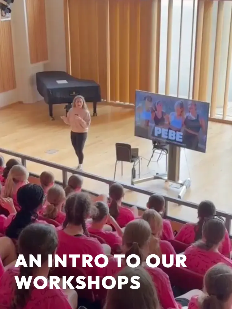 Large group of girls in pink shirts attending a PEBE sports bra workshop presentation.